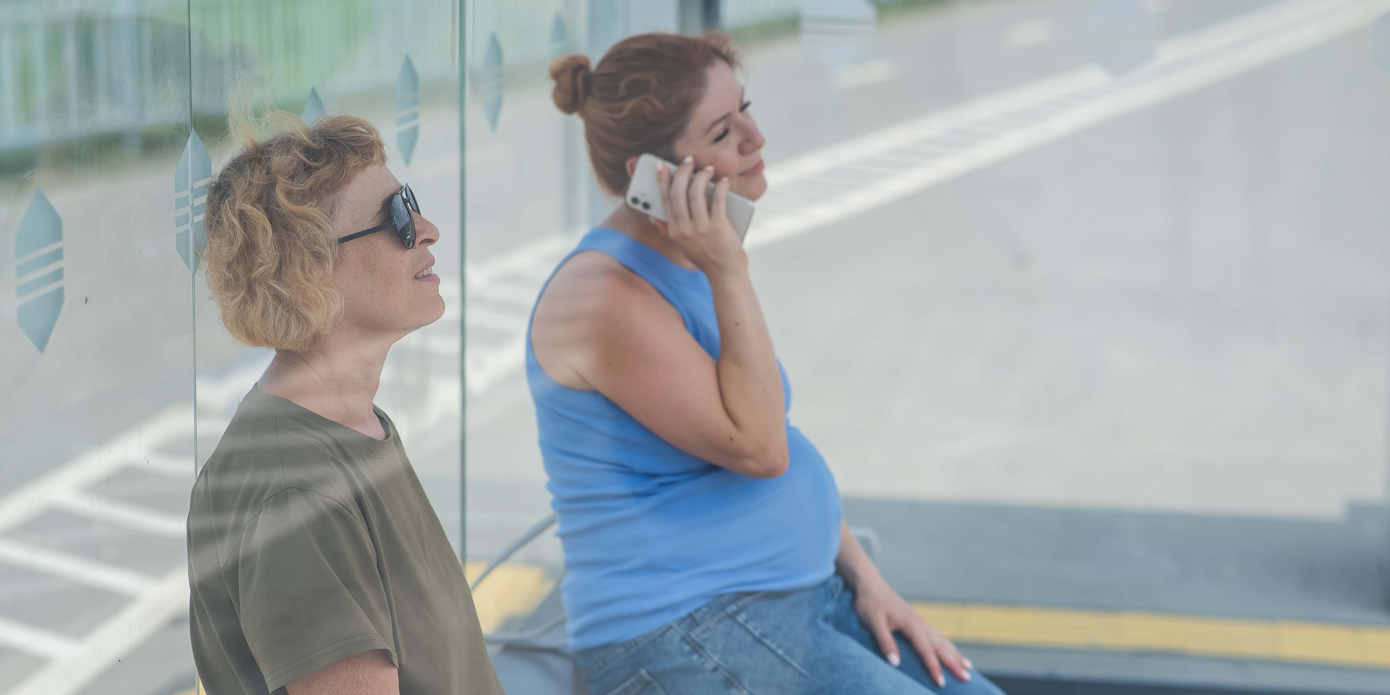 Una mujer ciega y otra embarazada esperan el autobús